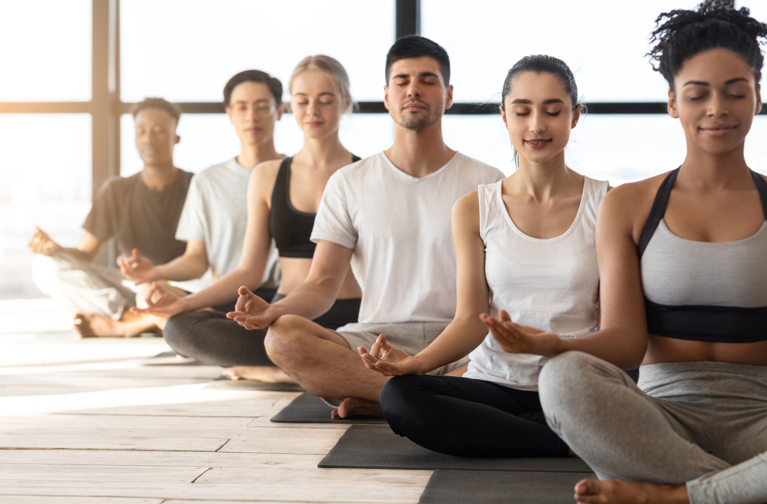 Group Meditation. Sporty Multiracial Men And Women Meditating Together During Yoga Class